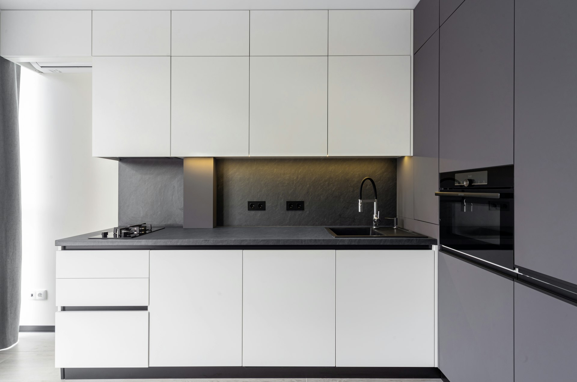 A modern kitchen features sleek white and gray cabinets.